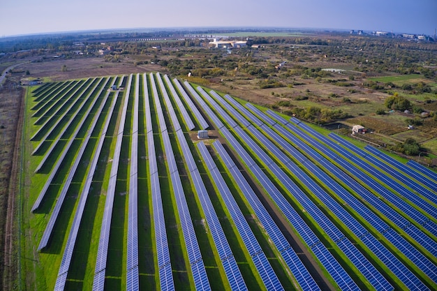 Riesiges Solarkraftwerk zur Nutzung von Sonnenenergie auf einer malerischen grünen Wiese in der Ukraine. Panorama-Drohnenaufnahme aus der Luft