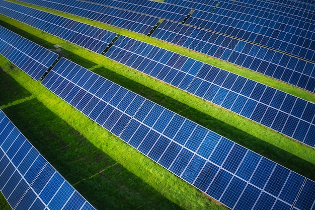 Riesiges Solarkraftwerk zur Nutzung von Sonnenenergie auf einer malerischen grünen Wiese in der Ukraine. Panorama-Drohnenaufnahme aus der Luft