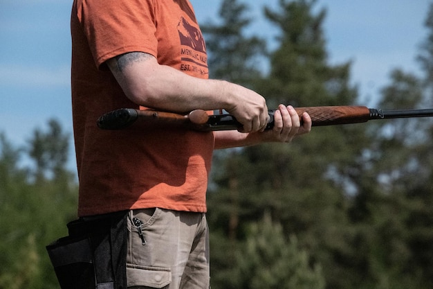 Foto rifle de caça disparando caça na floresta caçador carregando arma com balas um rifle em uma mão de homem closeup