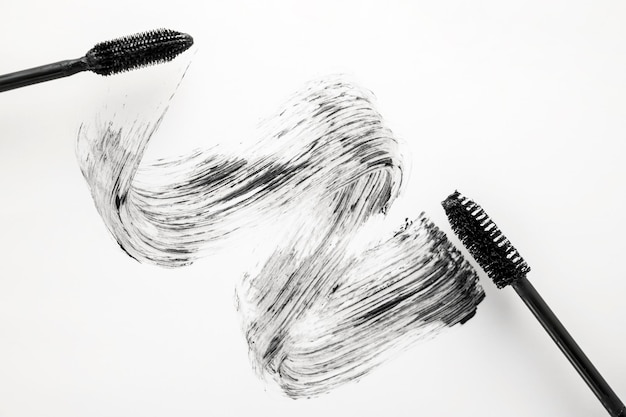 Foto rímel negro con aplicador de pincel closeup aislado sobre fondo blanco producto de belleza