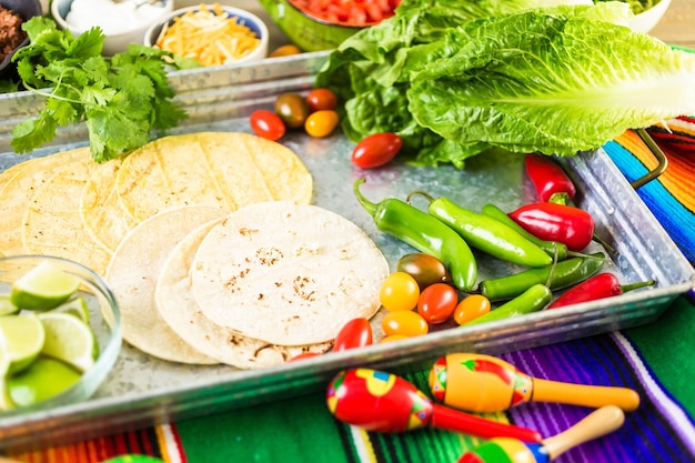 Rinderhack-Tacos mit Römersalat, Tomatenwürfeln, Radieschen und geriebenem Cheddar-Käse.