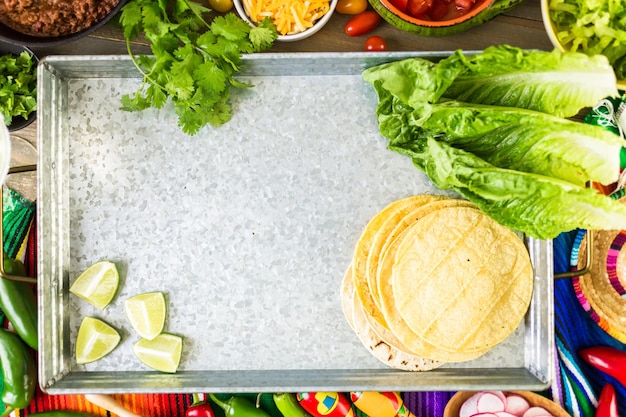 Rinderhack-Tacos mit Römersalat, Tomatenwürfeln, Radieschen und geriebenem Cheddar-Käse.