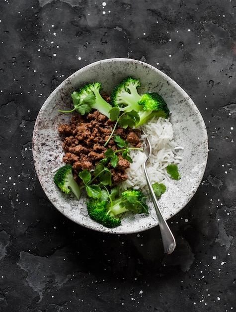 Rinderhackfleisch Basmatireis Brokkoli und Koriander köstliches Mittagessen im asiatischen Stil auf dunklem Hintergrund Draufsicht