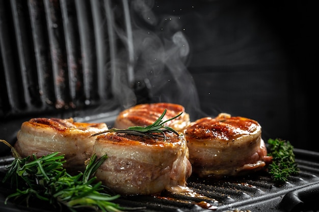 Rindersteak auf dem Grill kochen. Rinderfiletsteaks im Speckmantel. Filet Mignon. gemahlener Pfeffer in einer Gefrierbewegung,