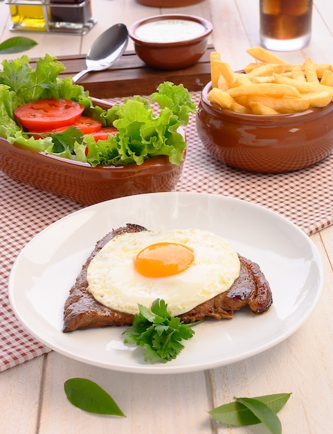 Rindersteak (Bife a Cavalo) - traditionelles brasilianisches Essen Steaks, weißer Reis, Farofa und Salat