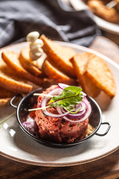 Rindertatar mit Toastbrot aus roten Zwiebeln und Knoblauch.