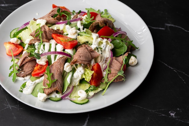 Rinderzungensalat mit frischem Gemüse Servieren von Speisen in einem Restaurant Foto für das Menü