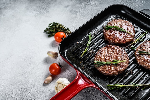 Rindfleisch-Burger-Pastetchen, die auf einer heißen Grillpfanne brutzeln