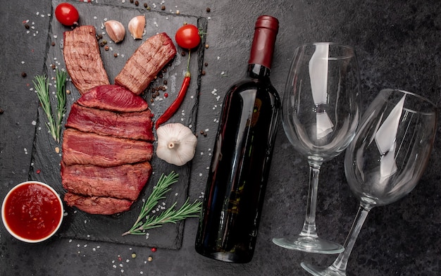 Rindfleisch-Osterhase, eine Flasche Wein und Gläser auf einem Steinhintergrund. Osterfestkonzept