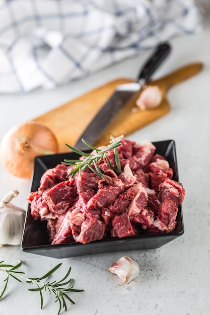 Rindfleisch. Roh geschnittenes Rindfleisch Knoblauch Zwiebel Salz Pfeffer und Rosmarin.