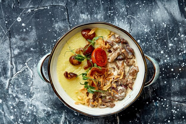 Rindfleisch Stroganoff mit Kartoffelpüree in einem Topf. Draufsicht, Steinhintergrund.