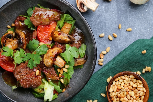 Rindfleisch und Champignons mit Pinienkernen