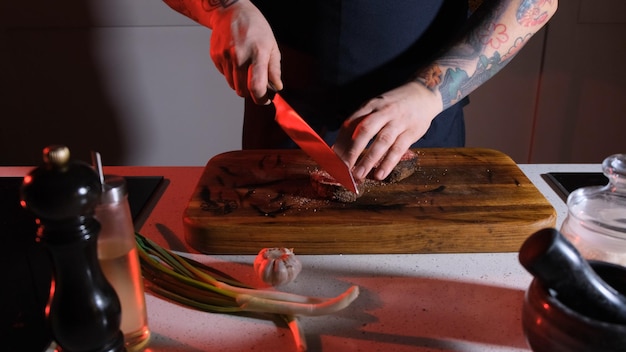 Foto rindfleisch von einem koch auf einem holztisch schneiden