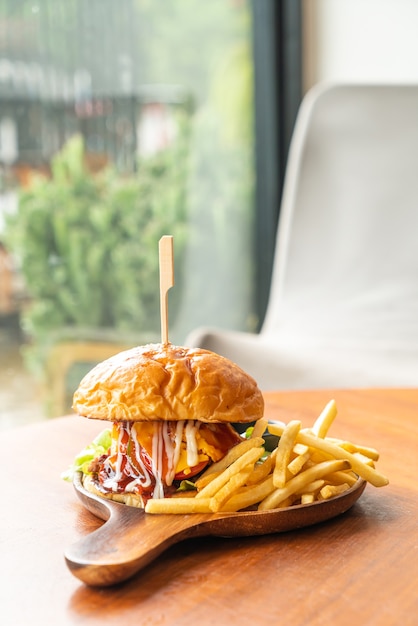 Rindfleischburger mit Käse und Sauce auf Holzteller