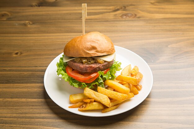 Rindfleischburger mit karamellisierten Zwiebeln und Pommes Frites.