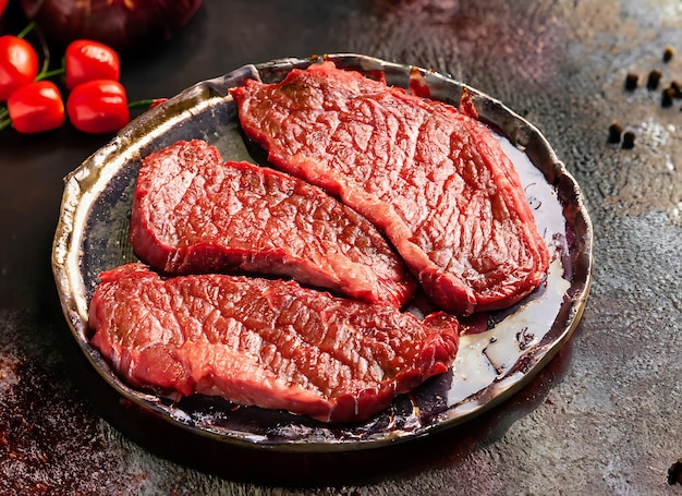 Rindfleischgrill, gebratenes rotes, dunkel geschnittenes Hintergrund, rohes Essen, Fleischsteak