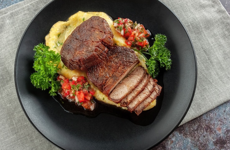 Foto rindfleischmedaillons mit tomatensalsa und cremiger polenta