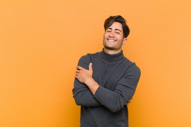 rindo alegremente com os braços cruzados, com uma pose relaxada, positiva e satisfeita