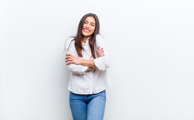 Rindo alegremente com os braços cruzados, com uma pose relaxada, positiva e satisfeita