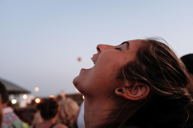 Foto rindo jovem mulher na cidade contra o céu