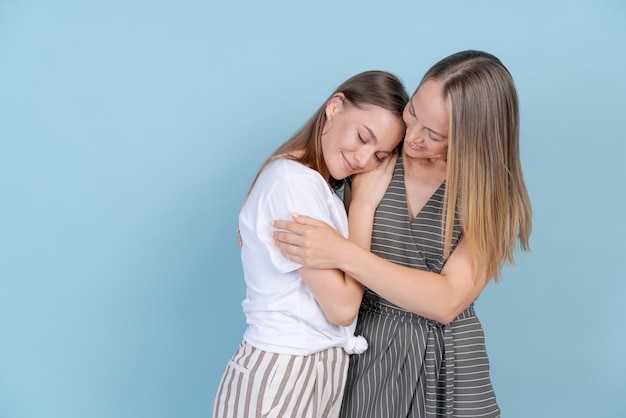Rindo mãe madura abraçando filha milenar feliz enquanto passa o tempo