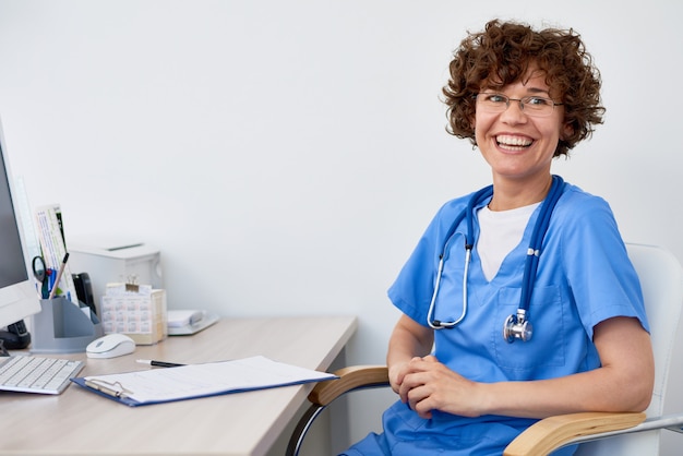 Foto rindo médica na mesa no escritório