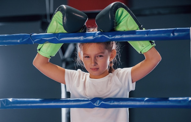 Foto en el ring de boxeo. niña en ropa deportiva está en el gimnasio tiene día de ejercicio.