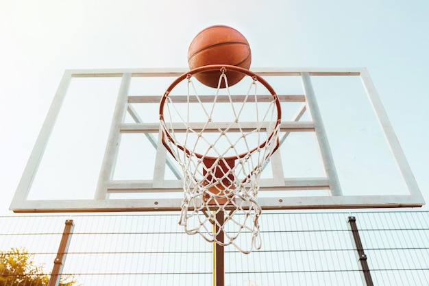 Ring und Basketball auf dem Hintergrund des Himmels und der Stadt Sport Lebensstil
