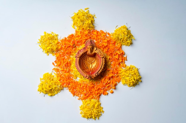 Ringelblumen-Rangoli-Design mit Öllampen für das Diwali-Festival.