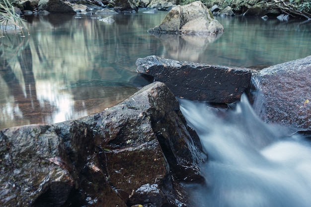 Río de agua cristalina que corre entre las rocas.