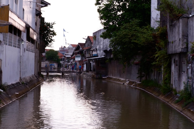 Un río atraviesa una ciudad con un puente al fondo.