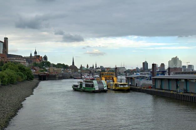 un río con un barco y una ciudad en el fondo