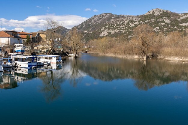 Un río con botes y montañas al fondo.