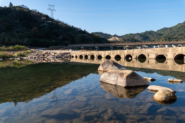 Foto el río del campo refleja la montaña, y los pueblos y los bosques están bajo el cielo azul.