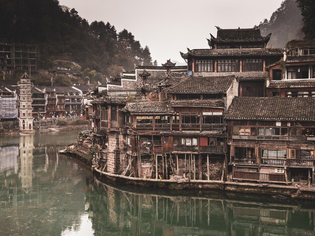 Foto río por casas y edificios contra árboles