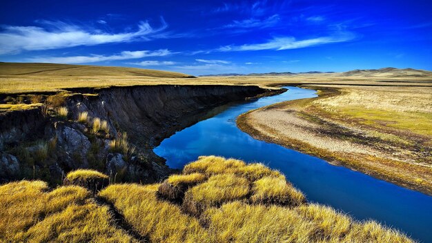 un río corre a través de un campo con un cielo en el fondo