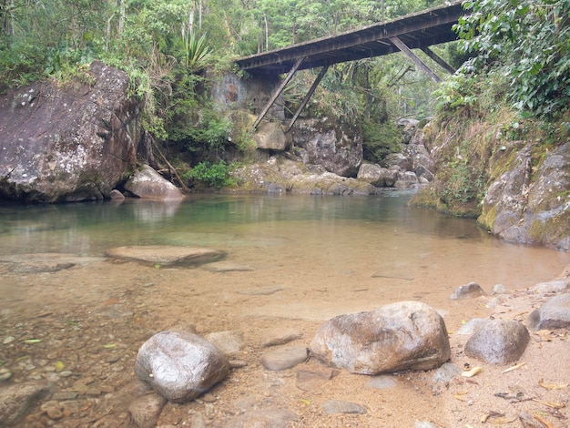 Rio de águas claras que flui sobre uma ponte no Brasil