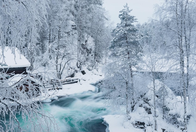 Rio descongelado de montanha em Winter Park na Lapônia, Finlândia, efeito mais azul