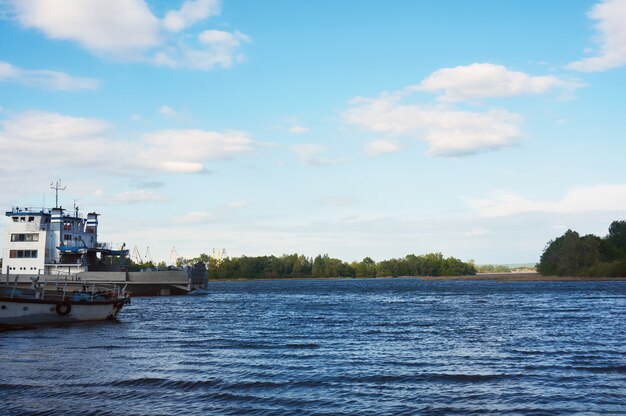 Río en un día soleado de verano con un hermoso cielo en las nubes. A la izquierda para ver el viejo barco.