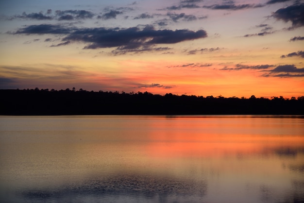 Rio e montanha no pôr do sol na noite azul e laranja fundo do céu