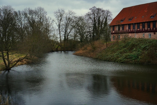 Foto un río con un edificio que tiene un techo rojo en él