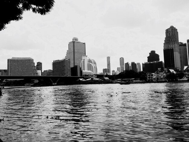 Río por edificios en la ciudad contra el cielo