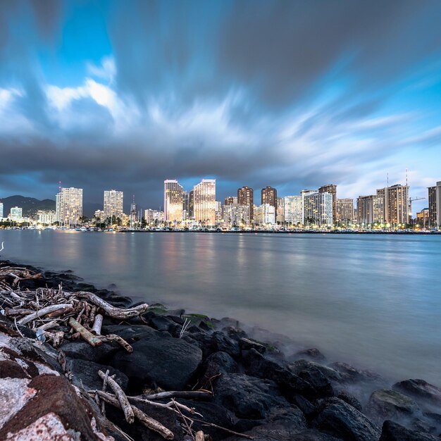 Foto río con edificios contra las nubes