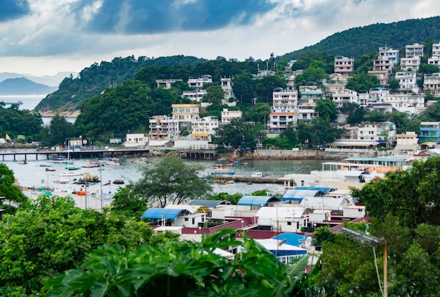 Rio em meio a edifícios e árvores contra o céu nublado