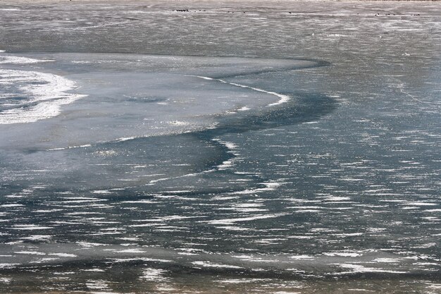 El río está bajo el hielo en un día soleado y helado.