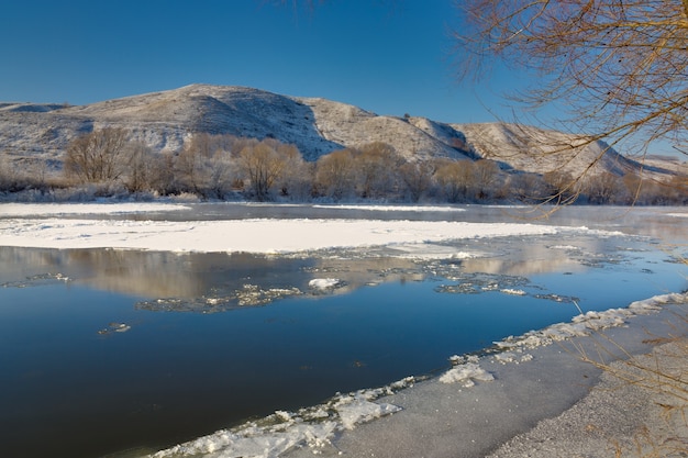 Foto río helado de las orillas montañosas y grandes témpanos de hielo
