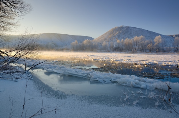 Río helado de las orillas montañosas y grandes témpanos de hielo