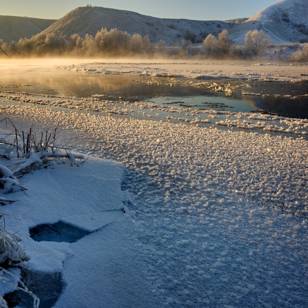 Río helado de las orillas montañosas y grandes témpanos de hielo