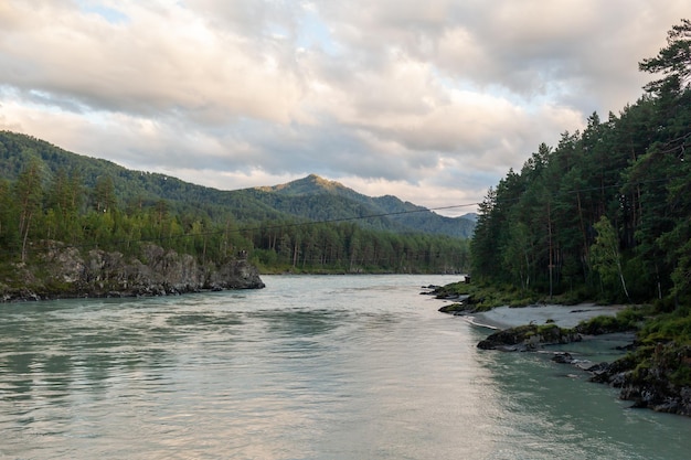 Un río de montaña ancho y caudaloso que fluye rápido. Grandes rocas sobresalen del agua.