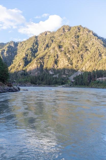 Un río de montaña ancho y caudaloso que fluye rápido. Grandes rocas sobresalen del agua.